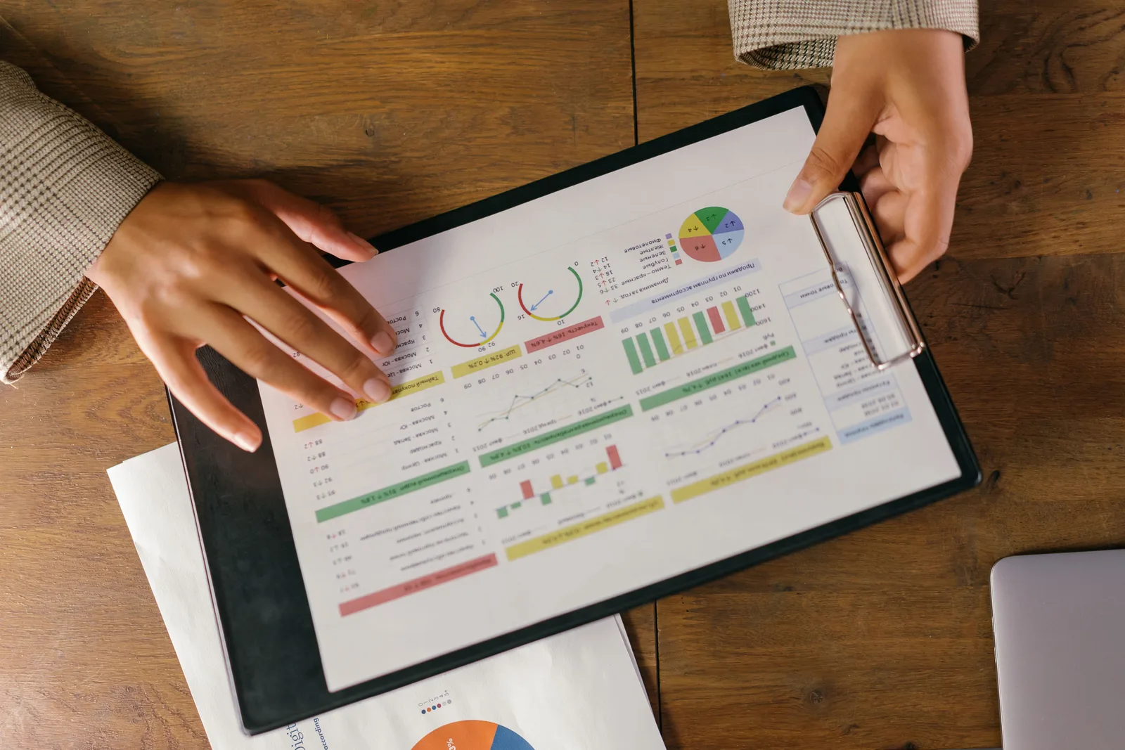Top view of hands holding a financial report with colorful graphs and charts, ideal for business presentations. 4 parts of PR measurement tools, explained